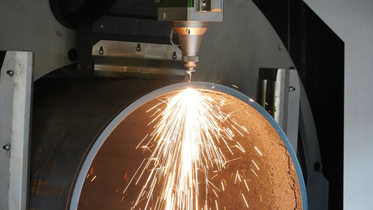Fiber laser cutting machine cutting sheet metal on the production floor in Jinan, China